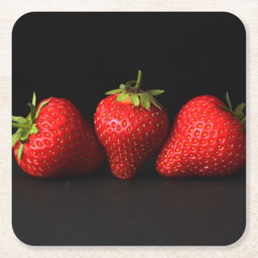 Drei Erdbeeren an der schwarzen Küste Rechteckiger Pappuntersetzer (Vorderseite)