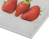 Drei Erdbeeren auf weißem Kbcnm Schneidebrett (Ecke)