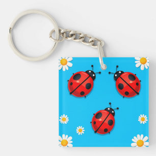 Drei farbenfrohe Ladybugs auf blauem Hintergrund Schlüsselanhänger
