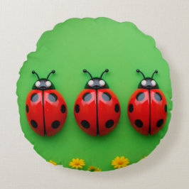 Drei farbenfrohe Ladybugs im grünen Hintergrund Rundes Kissen