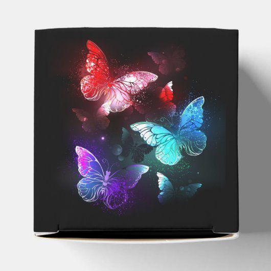 Drei glühende Schmetterlinge im Hintergrund Geschenkschachtel (Oben)