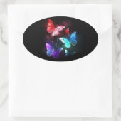 Drei glühende Schmetterlinge im Hintergrund Ovaler Aufkleber (Tasche)