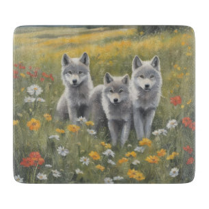 Drei graue Wolfswelpen warten und beobachten Schneidebrett