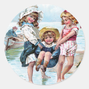 Drei kleine Mädchen spielen am Strand Runder Aufkleber