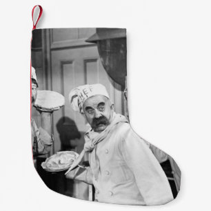 Drei Köche, die Kuchen für einen Kämpfen in der Kü Kleiner Weihnachtsstrumpf