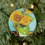 Drei Sonnenblumen | Vincent van Gogh Keramik Ornament<br><div class="desc">Drei Sonnenblumen (1888) von Vincent van Gogh ist ein lebendiges Stillleben, das die charakteristischen dicken Pinselstriche und den kühlen Farbgebrauch des Künstlers zeigt. Das Gemälde besteht aus drei Sonnenblumen in einer einfachen Vase, deren goldene Blütenblätter im Kontrast zum aqua-blauen Hintergrund stehen. Van Gogh's lebhafte gelbe Palette bringt Energie und Leben...</div>