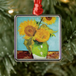 Drei Sonnenblumen | Vincent van Gogh Ornament Aus Metall<br><div class="desc">Drei Sonnenblumen (1888) von Vincent van Gogh ist ein lebendiges Stillleben, das die charakteristischen dicken Pinselstriche und den kühlen Farbgebrauch des Künstlers zeigt. Das Gemälde besteht aus drei Sonnenblumen in einer einfachen Vase, deren goldene Blütenblätter im Kontrast zum aqua-blauen Hintergrund stehen. Van Gogh's lebhafte gelbe Palette bringt Energie und Leben...</div>