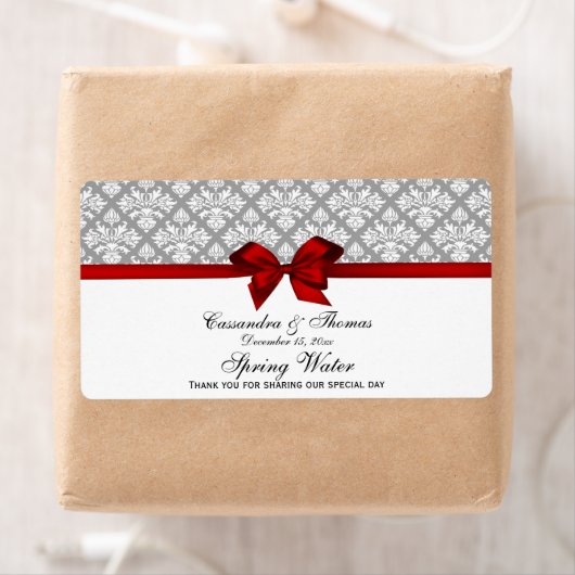 Dunkelgraues weißes Damaskochetikett mit rotem Bow (Insitu)