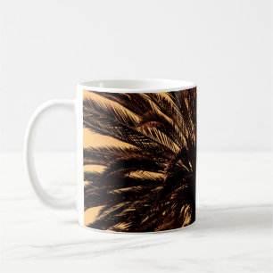 Dunkle Silhouetten von Dattelpalmen gegen leuchten Kaffeetasse