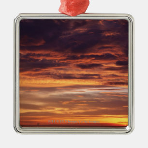 Dunkle Wolken in Orange gestreiftem Himmel Silbernes Ornament
