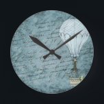 Dusk Blue Hot Air Balloon Steampunk Handwriting Runde Wanduhr<br><div class="desc">Matches other Steampunk hot air balloon design items such as cards and wrapping paper. Great for aviators and other air travel fans. This design features a Victorian Steampunk Hot Air Balloon gently flying in front of a scrapbook background page filled with handwriting washed with shades of soft, dusk blue. This...</div>