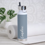 Dusty Blue Personalisiert Wedding Bridesmaid Trinkflasche<br><div class="desc">Gönnen Sie Ihrer Hochzeitsjury oder Ihrer Trauzeugin diese trendige, vakuumisolierte Wasserflasche, die ihren Namen in weißem, stilisiertem Schrift auf einem staubblauen Hintergrund hat, der zu Ihrem Hochzeitsfarbenschema passt. Stellen Sie die Flasche nach Belieben durch Bearbeiten und Ersetzen des Namens durch Ihren eigenen Namen ein. Wählen Sie Ihre Wasserflasche. Erhältlich in...</div>