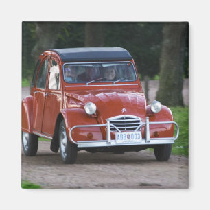 Ein alter roter Citroen 2CV mit einer lächelnden F Magnet