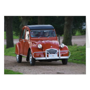 Ein alter roter Citroen 2CV Wagen mit einer lächel