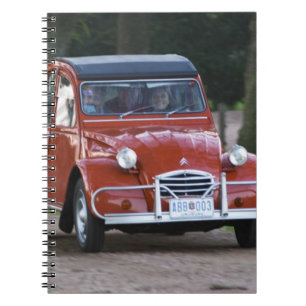 Ein alter roter Citroen 2CV Wagen mit einer lächel Notizblock
