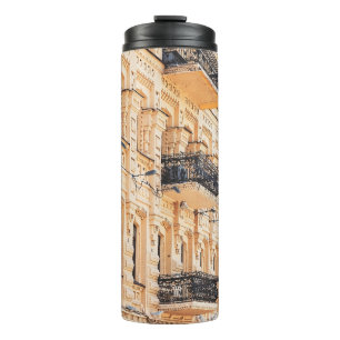 Ein altes gelbes Haus mit schmiedeeisernen Balkone Thermosbecher