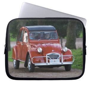 Ein altes, rotes Citroen 2CV Auto mit einer läche Laptopschutzhülle