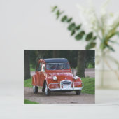 Ein altes, rotes Citroen 2CV Auto mit einer lächel Postkarte (Stehend Vorderseite)