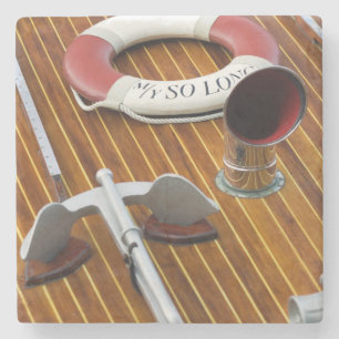 Ein Anker und eine Leben-Boje auf einem hölzernen Steinuntersetzer