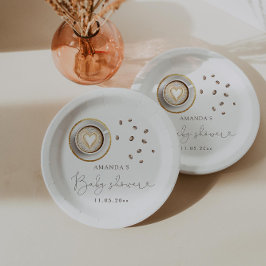 Ein Baby brütet eine Kaffeemaschine. Pappteller