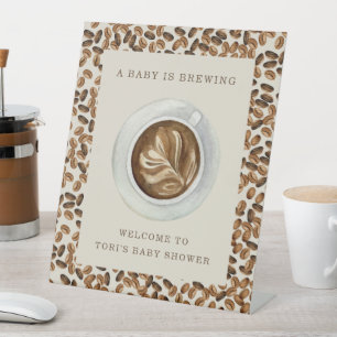 Ein Baby brütet Kaffeebohnen Babydusche Sockelschild
