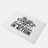 Ein Beispiel für Glauben und Liebe in Aktion sein Fußmatte (Schrägansicht)