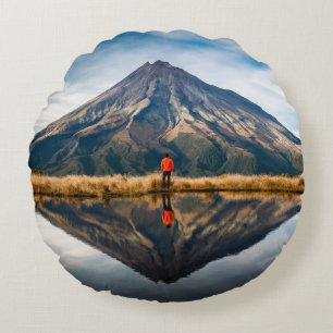 Ein Bergsteiger mit einem orangefarbenen Kleid in  Rundes Kissen