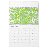 Ein brauner Holztisch hält eine Glasflasche mit Ol Kalender (Mär 2027)