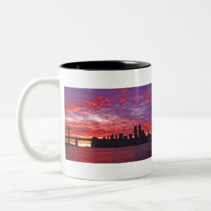 Ein brillanter Sonnenuntergang mit der Silhouette Zweifarbige Tasse