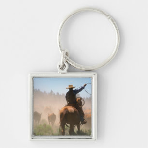 Ein Cowboy, der bei der Arbeit mit der Herde auf e Schlüsselanhänger