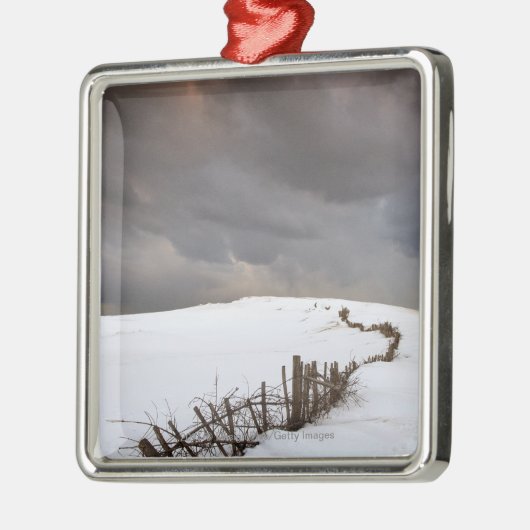 Ein defekter Zaun entlang einer Schnee Silbernes Ornament (Links)