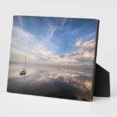 Ein einsames Segelboot in den ruhigen Gewässern vo Fotoplatte (Seite)