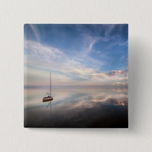 Ein einziges Segelboot auf dem ruhigen Wasser von Button (Vorderseite)