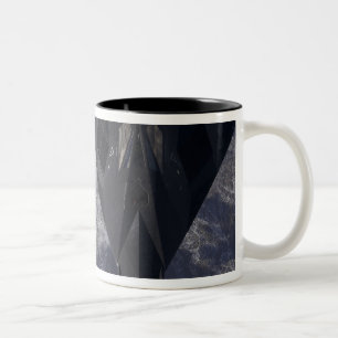Ein F-117A-Nachtwächter fliegt hoch über dem Berg Zweifarbige Tasse
