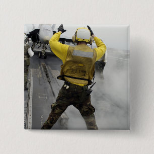 Ein Flugzeugdirektor signalisiert einer F/A-18C Button