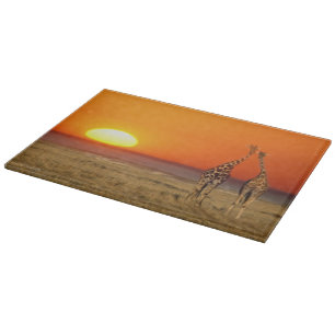 Ein Giraffenpaar geht in den Sonnenuntergang, in Schneidebrett