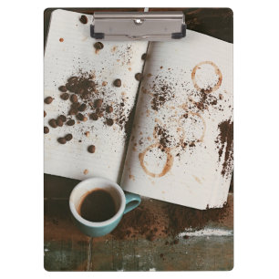 Ein heißer Kaffee mit Büchern und Bohnen Klemmbrett