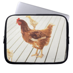 Ein Huhn und zwei Küken auf einem hölzernen Bode Laptopschutzhülle