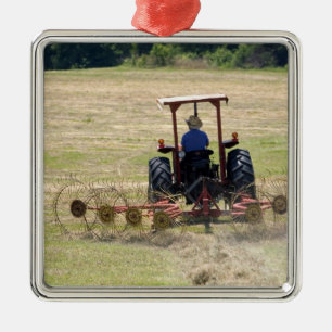 Ein junger Junge fährt einen Traktor zur Ernte Silbernes Ornament