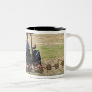 Ein junger Junge fährt einen Traktor zur Ernte Zweifarbige Tasse