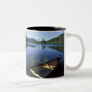 Ein Kanu ruht am Ufer des Little Long Pond Zweifarbige Tasse