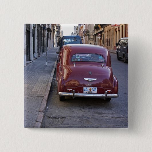 Ein klassisches altes Peugeot-Auto auf einer Straß Button (Vorderseite)