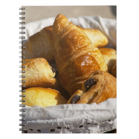 Ein Korbfrühstück mit Croissants und Notizblock (Vorderseite)