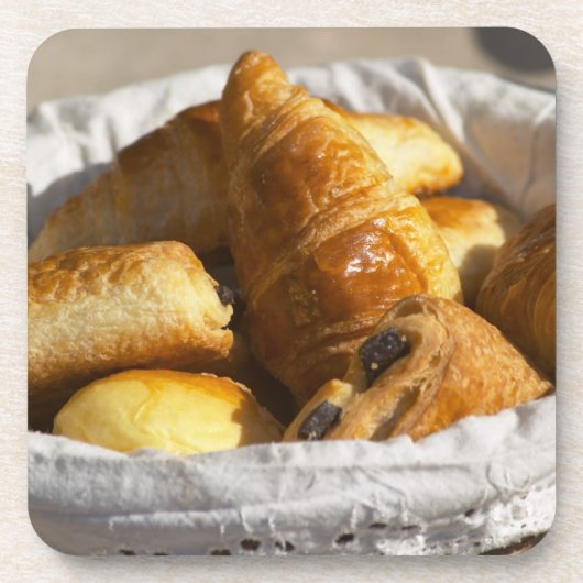 Ein Korbfrühstück mit Croissants und Untersetzer (Vorderseite)