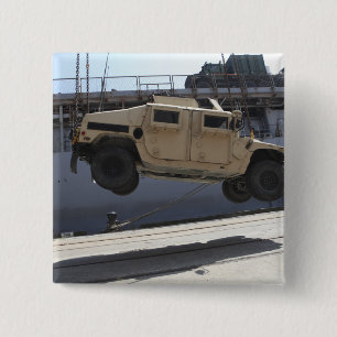 Ein Kran hebt ein M998 Humvee an Button