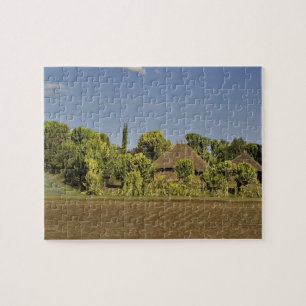 Ein landwirtschaftlich genutztes Feld vor Häusern Puzzle