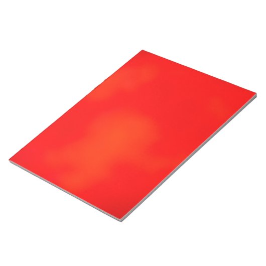 Ein lebendiges rotes Notizbuch mit einer subtilen Notizblock (angewinkelt)