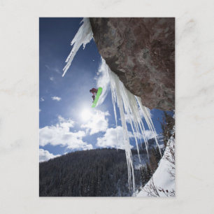 Ein männlicher Snowboarder springt weg von einem Postkarte