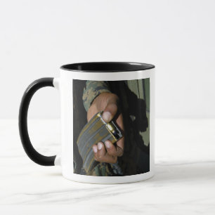 Ein Marinesoldat lädt leere Munitionsrunden Tasse