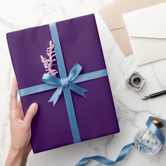 Ein minimalistischer violetter Hintergrund mit dez Geschenkpapier (Schenken)